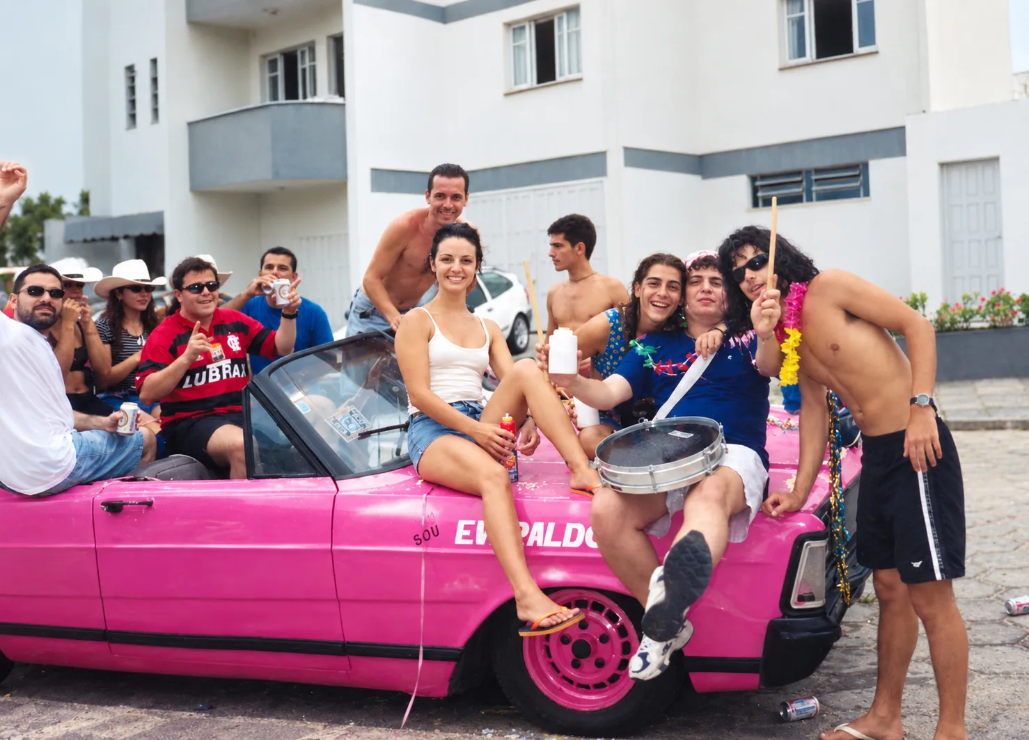A turma de amigos de 1998 sobre o carro conversível pintado de rosa, nas ruas de Laguna